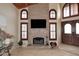 Cozy living room features a brick fireplace with mounted TV and wood-trimmed arched windows at 21609 N 61St Ave, Glendale, AZ 85308