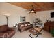 Cozy living room features a leather sofa, unique shelving, and a stylish ceiling fan at 21609 N 61St Ave, Glendale, AZ 85308