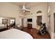 Large main bedroom featuring wood floors, ceiling fan, exercise equipment, and a TV at 21609 N 61St Ave, Glendale, AZ 85308