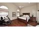 Spacious main bedroom boasting hardwood floors, ceiling fan, and an elliptical machine at 21609 N 61St Ave, Glendale, AZ 85308