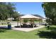 Community park featuring a covered picnic pavilion with tables, surrounded by grassy fields and mature trees for outdoor enjoyment at 21609 N 61St Ave, Glendale, AZ 85308