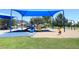 Community playground with a blue shade structure, play equipment, swings, and a sandy area for to play safely at 21609 N 61St Ave, Glendale, AZ 85308