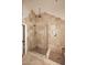 Walk-in shower with a large tiled shower stall, glass enclosure, multiple shower heads, and built-in niche at 21609 N 61St Ave, Glendale, AZ 85308