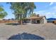 Spacious backyard with mature tree and large gravel area with a covered patio at 2215 W Highland Ave, Phoenix, AZ 85015