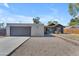 Modern exterior featuring concrete driveway, textured stucco, gray door, and well-maintained gravel landscaping at 2215 W Highland Ave, Phoenix, AZ 85015