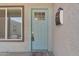 Close-up of a charming blue front door with a window, complemented by a mailbox and welcome mat at 2215 W Highland Ave, Phoenix, AZ 85015