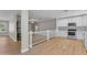 Open floor plan with a white kitchen featuring stainless steel appliances and wood floors at 2215 W Highland Ave, Phoenix, AZ 85015