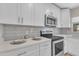 Close-up of a modern kitchen showcasing white cabinets, quartz countertops, and stainless steel appliances at 2215 W Highland Ave, Phoenix, AZ 85015
