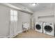 Bright laundry room featuring a sink, modern washer and dryer, and storage shelves for convenience at 2215 W Highland Ave, Phoenix, AZ 85015