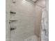 Tiled shower with neutral colors, shower curtain, and built-in shelves at 2215 W Highland Ave, Phoenix, AZ 85015