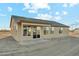 The rear exterior view reveals a cozy covered patio and multiple windows for ample natural light at 22351 S Manzanilla Rd, Buckeye, AZ 85326