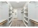Spacious walk-in closet with ample shelving and natural wood rods at 22351 S Manzanilla Rd, Buckeye, AZ 85326