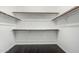 A walk-in closet featuring dark hardwood floors, neutral walls, and built-in shelving at 2330 E Stephens Pl, Chandler, AZ 85225