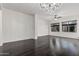 Spacious living room with dark hardwood floors, two windows and a modern chandelier at 2330 E Stephens Pl, Chandler, AZ 85225