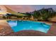 Inviting swimming pool with a sunshade, stone accents, and lush greenery providing a private backyard oasis at 2330 E Stephens Pl, Chandler, AZ 85225
