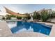 Serene pool featuring a sunshade and waterfall features, creating a peaceful retreat for relaxation and recreation at 2330 E Stephens Pl, Chandler, AZ 85225