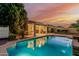 Sparkling pool featuring a covered patio with overhead lights, perfect for outdoor living and entertaining during sunset at 2330 E Stephens Pl, Chandler, AZ 85225