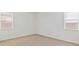Bright bedroom showcases neutral carpet, two windows, and ample natural light at 25183 N 183Rd Dr, Wittmann, AZ 85361