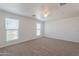 Bright bedroom with carpet, two large windows with blinds, and a ceiling fan at 2847 S 161St Dr, Goodyear, AZ 85338