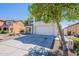 View of the two-story home, showing the long driveway, and the two-car garage, and a healthy tree in the front yard at 2847 S 161St Dr, Goodyear, AZ 85338