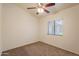 A bright bedroom featuring neutral walls, carpet, a ceiling fan, and a window that provides natural light at 31 W Loma Vista Dr # 102, Tempe, AZ 85282