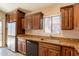 A well-lit kitchen features wooden cabinetry, granite countertops, and stainless steel appliances at 31 W Loma Vista Dr # 102, Tempe, AZ 85282