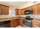 Bright kitchen featuring dark wood cabinets, granite countertops, and stainless steel appliances at 31 W Loma Vista Dr # 102, Tempe, AZ 85282