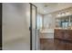Modern bathroom with wood floors, soaking tub, glass shower, and wood vanity at 3721 W Aracely Dr, New River, AZ 85087