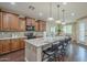 Well-equipped kitchen with wood cabinets, granite countertops, barstool seating, stainless appliances, and modern lighting at 3721 W Aracely Dr, New River, AZ 85087