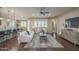 Bright living room featuring hardwood floors, contemporary decor, a ceiling fan, and views of the kitchen and dining areas at 3721 W Aracely Dr, New River, AZ 85087
