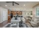 Open living room with dark wood floors, modern furniture, a ceiling fan, and a clear view of the adjoining kitchen at 3721 W Aracely Dr, New River, AZ 85087