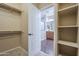 Walk-in closet with shelving, rods, and carpeted floor with open door to bathroom at 3721 W Aracely Dr, New River, AZ 85087