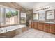 Bathroom featuring double sinks, tub, window, and a glass shower with tile surround at 3740 W Kent Dr, Chandler, AZ 85226