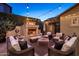 Cozy backyard featuring a stone fireplace, comfortable seating, and ambient lighting at 3741 E Ember Glow Way, Phoenix, AZ 85050