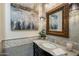 This powder bathroom features elegant wallpaper, stylish lighting, and a black marble vanity with a large gilded mirror at 3741 E Ember Glow Way, Phoenix, AZ 85050
