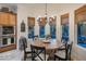 This dining room features a round table, a modern chandelier, and natural light from the surrounding windows at 3741 E Ember Glow Way, Phoenix, AZ 85050
