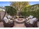 Cozy fire pit surrounded by cushioned seating and mature landscaping creates a charming outdoor space at 3741 E Ember Glow Way, Phoenix, AZ 85050