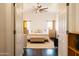 Bright bedroom featuring wood floors, a ceiling fan, and an upholstered bench at the foot of the bed at 3756 E Alamo St, San Tan Valley, AZ 85140