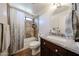 Well-lit bathroom featuring a granite countertop, round mirror, and tiled shower with neutral earth tones at 4126 E Windrose Dr, Phoenix, AZ 85032