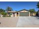 Charming single-story home featuring a desert landscape, green garage door, and a decorative sun accent at 4126 E Windrose Dr, Phoenix, AZ 85032