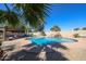 Beautiful swimming pool with rock feature, shaded seating, and lush greenery in a private backyard at 4126 E Windrose Dr, Phoenix, AZ 85032