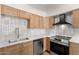 Kitchen with stainless steel appliances, quartz counters, gold hardware and light wooden cabinets at 4147 W Reade Ave, Phoenix, AZ 85019