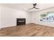 Bright living room featuring wood floors, a modern fireplace, ceiling fan and ample natural light at 4147 W Reade Ave, Phoenix, AZ 85019