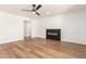 Bright living room featuring wood floors, a modern fireplace, ceiling fan and neutral paint at 4147 W Reade Ave, Phoenix, AZ 85019