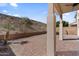 Paver backyard featuring a covered patio and mature desert landscaping in a hillside setting at 421 W Mountain Sage Dr, Phoenix, AZ 85045
