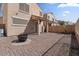 Paver backyard featuring an outdoor fire pit, covered patio, and mature desert landscaping at 421 W Mountain Sage Dr, Phoenix, AZ 85045