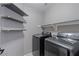 A well-organized laundry room with floating shelves and updated washer and dryer at 421 W Mountain Sage Dr, Phoenix, AZ 85045