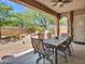 Covered patio featuring a dining table and chairs with a view of the landscaped backyard at 43510 N 44Th Ave, New River, AZ 85087
