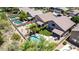 Tranquil backyard with a pool, lush green lawn, mature trees, and a covered patio for outdoor dining at 4426 E Coyote Wash Dr, Cave Creek, AZ 85331