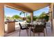 Covered patio features a grill and outdoor seating overlooking the lush backyard and sparkling pool at 4426 E Coyote Wash Dr, Cave Creek, AZ 85331